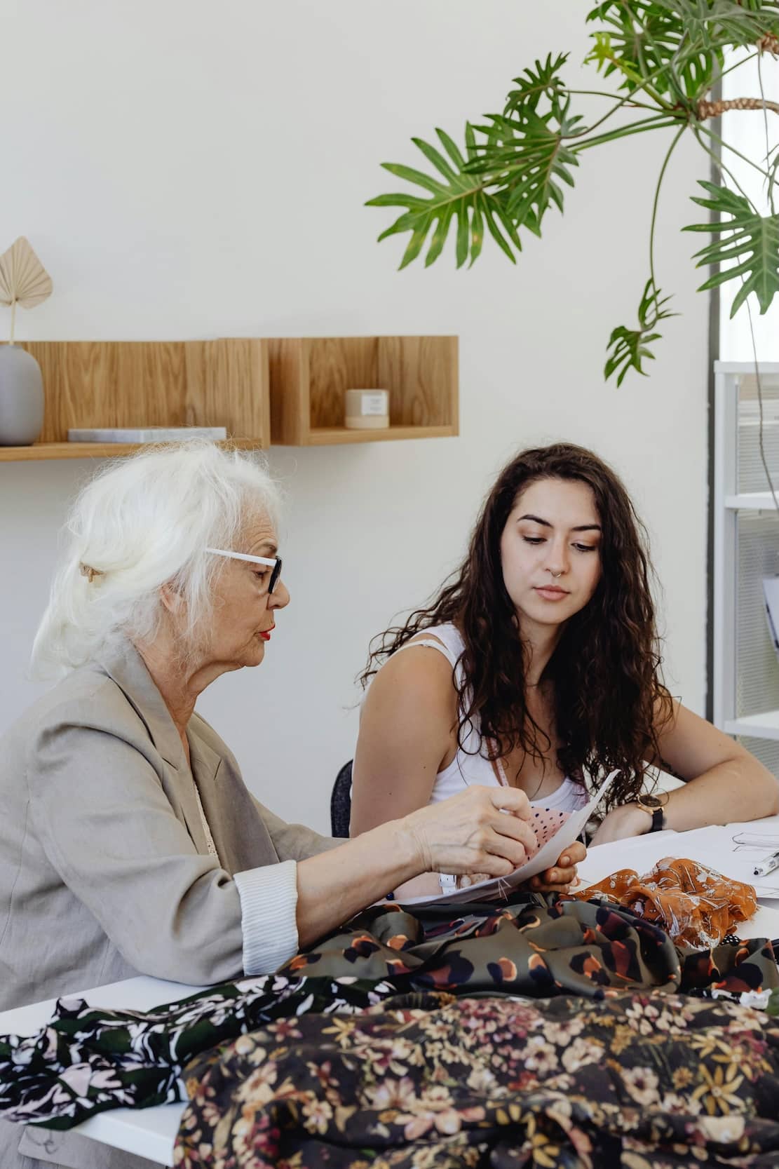 Older and younger woman working together on textile designs, representing cross-generational collaboration in a family business.